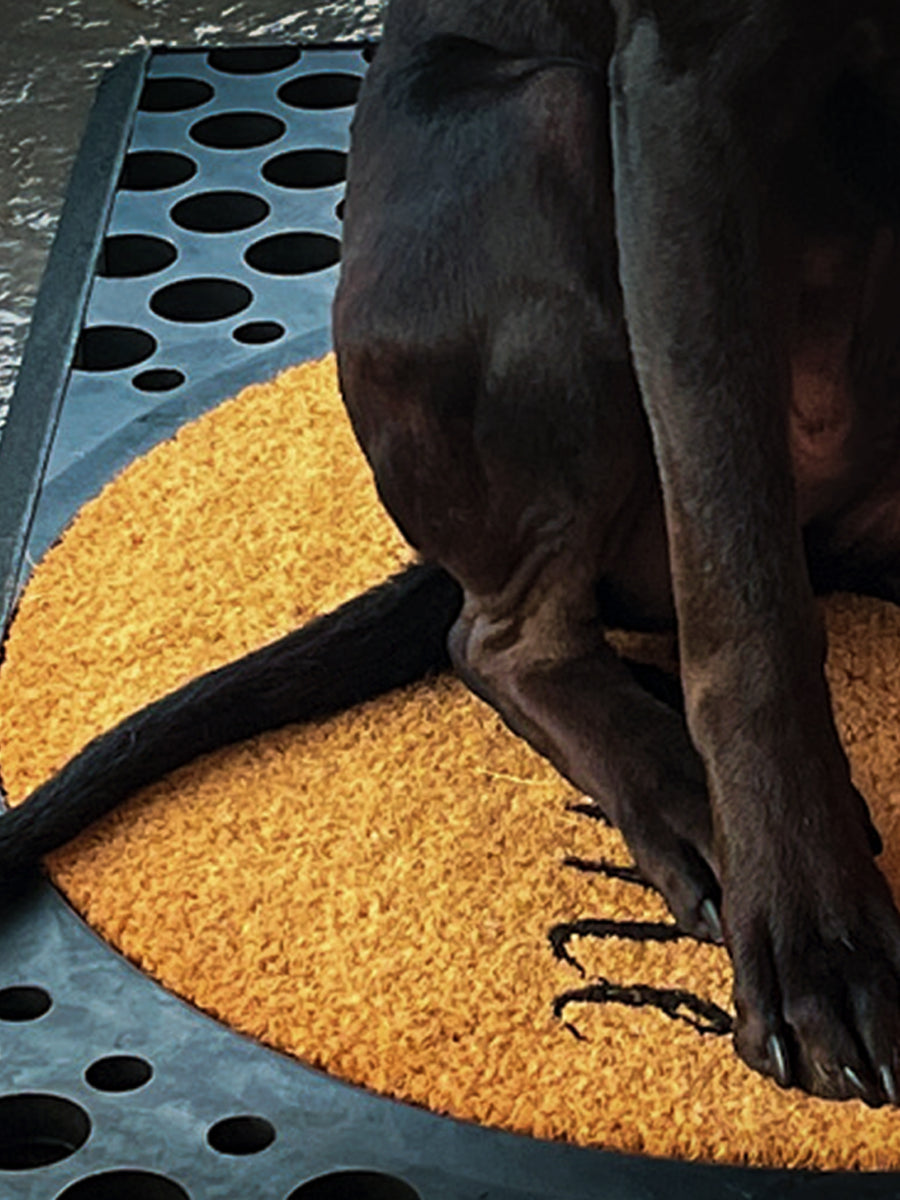 Round coir doormat with rubber base at entryway